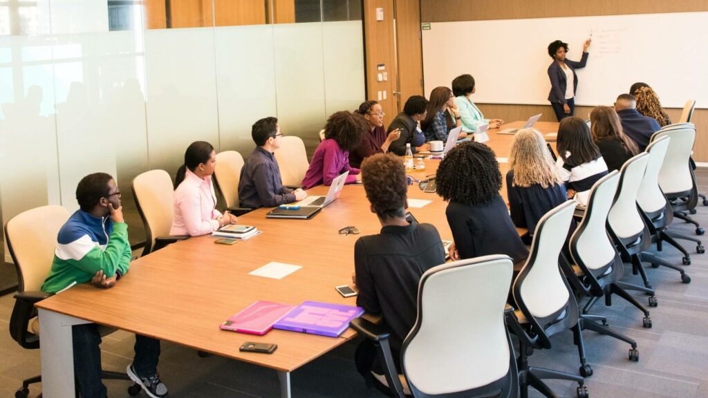 Alida Miranda-Wolff, How to Build Affinity Groups article image, conference room full of people listening during a meeting