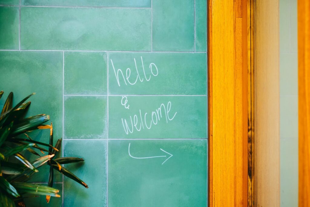 Alida Miranda-Wolff, The Ultimate Guide to Structuring a 90-Day Onboarding Plan article, feature image, Hello and Welcome written on green tile